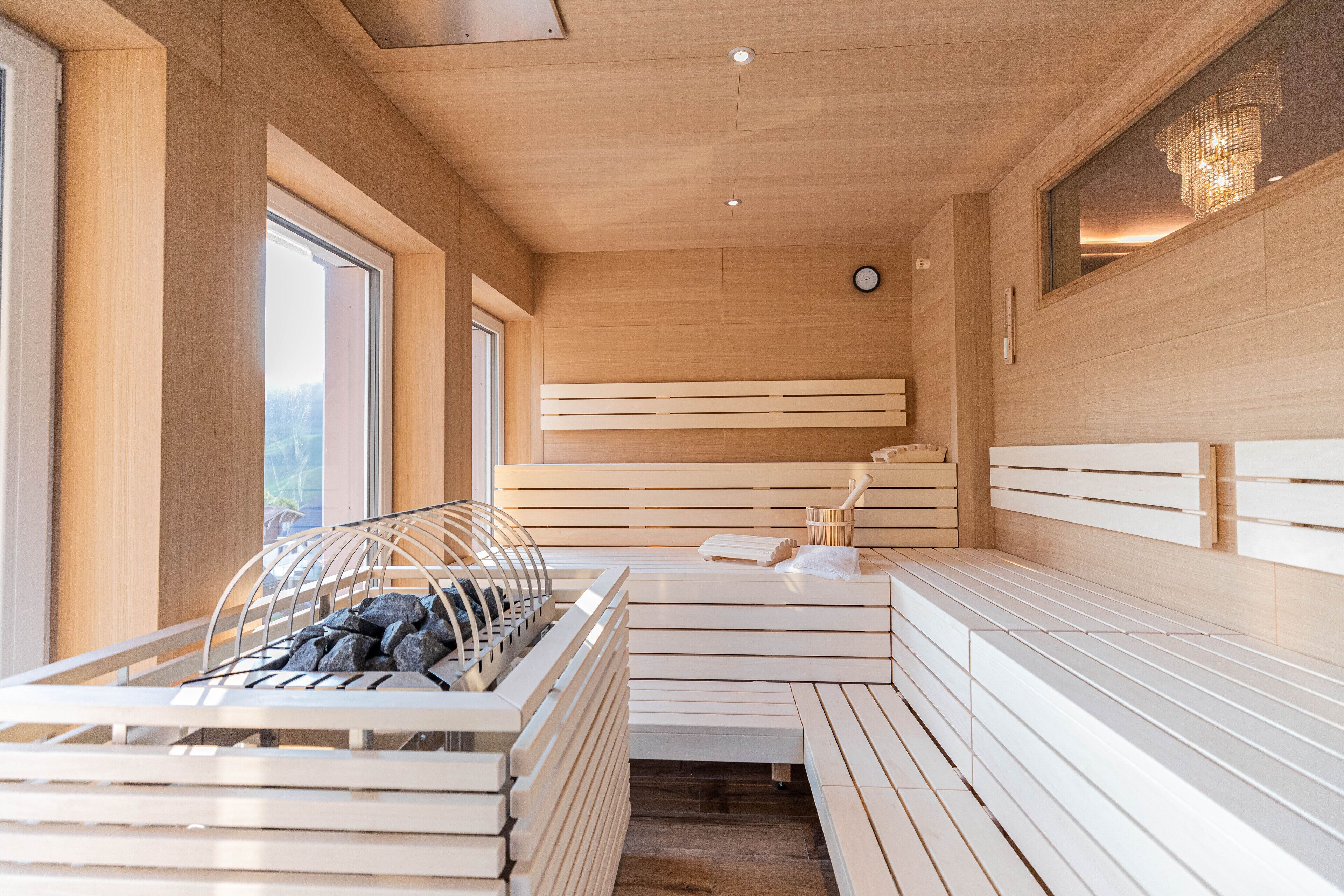 A sauna with wooden benches and a stone bench.
