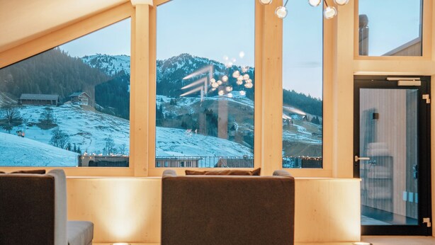 Ein modernes Interieur mit einem großen Fenster mit Blick auf eine verschneite Landschaft.