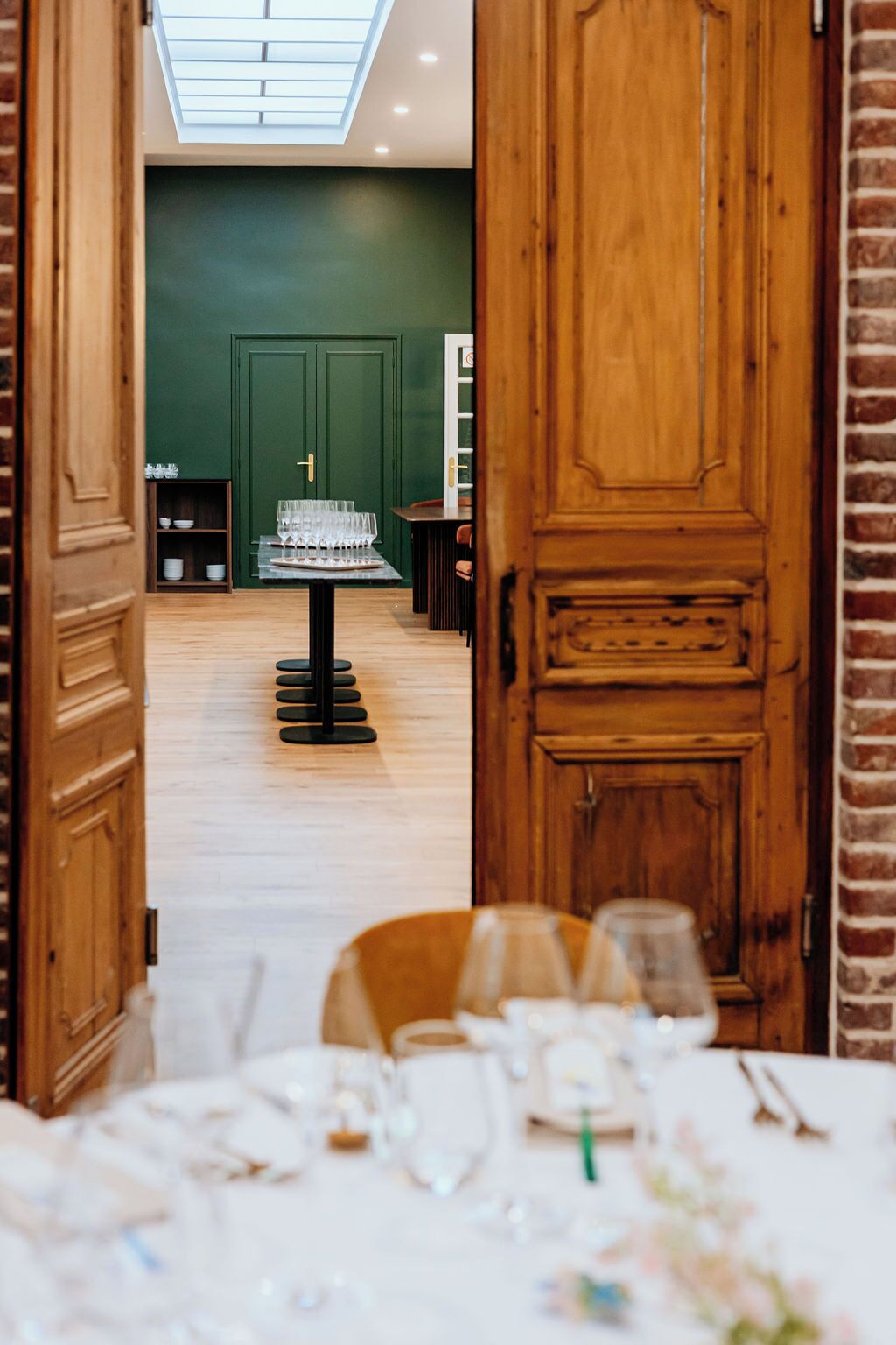 Un restaurant avec un décor intérieur en bois, un mur végétal et une verrière.
