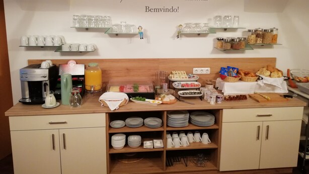 Morgenmadsbuffet med kaffemaskiner, juiceautomater og et udvalg af mad.