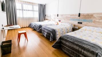 Quarto de hotel com duas camas, uma escrivaninha e uma cadeira.