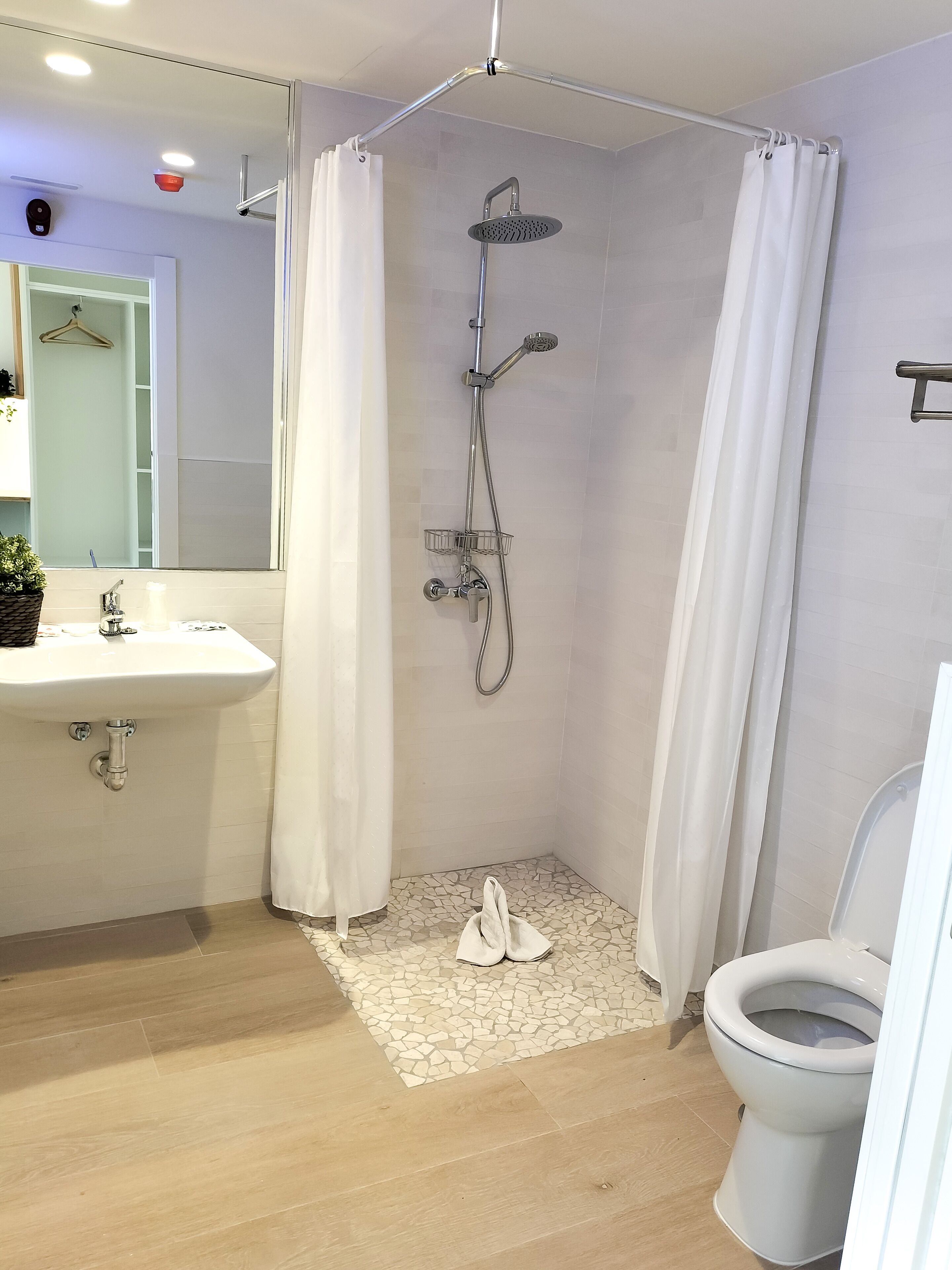 Un baño moderno con ducha, lavamanos e inodoro.