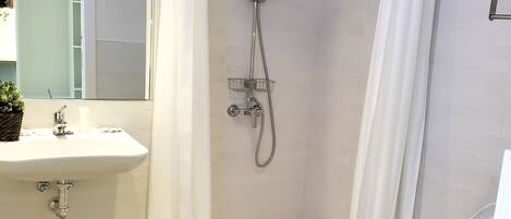 A modern bathroom with a shower, sink, and toilet.