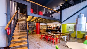 A multi-level interior with a staircase, dining area, and seating. - Far Home Bernabeu (Madrid)