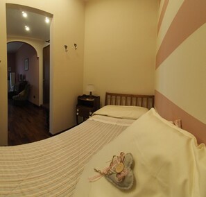A bedroom with a bed, a nightstand, a lamp, and a heart-shaped decoration on the bed. - Ca' Rosa Bed & Breakfast (Malnate)