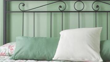 A bed with a metal headboard, two bedside lamps, and a floral bedspread.