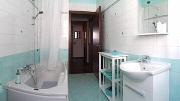 Un baño con bañera, lavabo y ducha.
