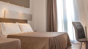 A modern hotel room with a large bed, a chair, and a ceiling light fixture. - I Cordari B&B (Vieste)