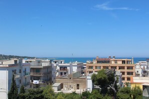 Un paysage urbain côtier avec des immeubles à plusieurs étages, des balcons et une vue dégagée sur la mer.
