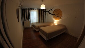 A bedroom with two beds, a radiator, a hanging light fixture, and a wall mural.