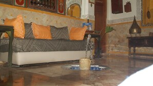 A traditional Moroccan interior with a patterned sofa, a fountain, and ornate wall decorations. - Museum House - Dar Melyani (Fes)
