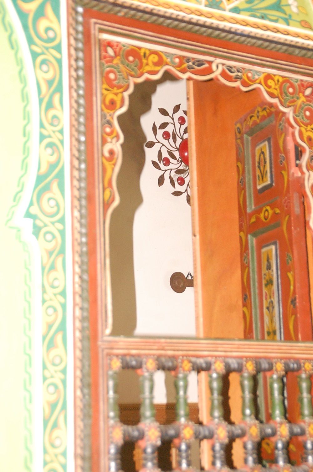 A traditional wooden door with intricate carvings and a decorative metal grille.