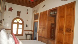 A bedroom with a large bed, wooden wardrobe, and a small table. - Museum House - Dar Melyani (Fes)