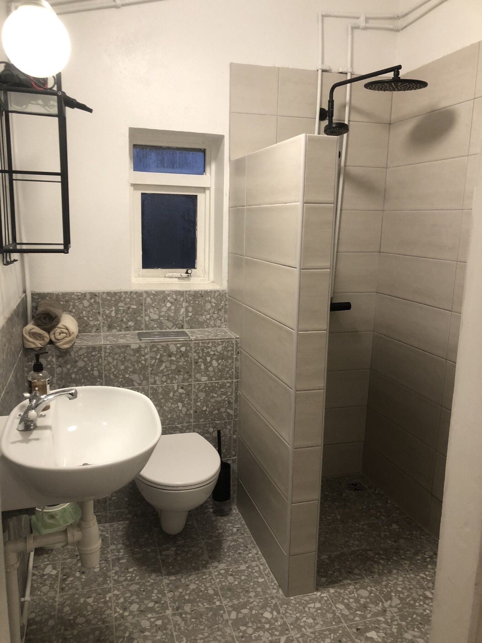 A bathroom with a sink, toilet, and shower.
