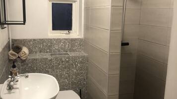 A bathroom with a sink, toilet, and shower.