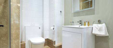 Un baño moderno con inodoro, ducha y lavamanos.