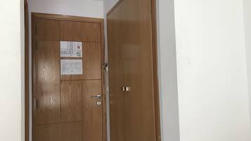Un armario de madera con una puerta, un ventanal pequeño y un tirador.