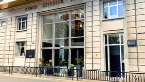 Fachada de hotel con amplias ventanas, un letrero que dice "BEX HOTEL" y un letrero que indica "BEX Rooftop and Lounge".