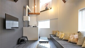Ein modernes Interieur mit einer Sofagarnitur, einem Fernseher und einer Küchenzeile.