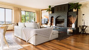A modern living room with a fireplace, a sofa, and a large window.
