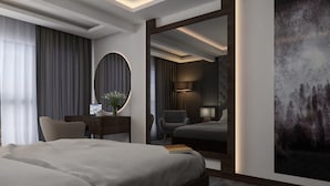 Una habitación de hotel moderna con una cama grande, un escritorio con una lámpara, una silla y un espejo amplio.