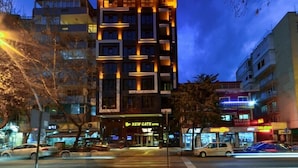Un hotel de varios pisos con un letrero llamativo que dice "NEW GATE HOTEL".