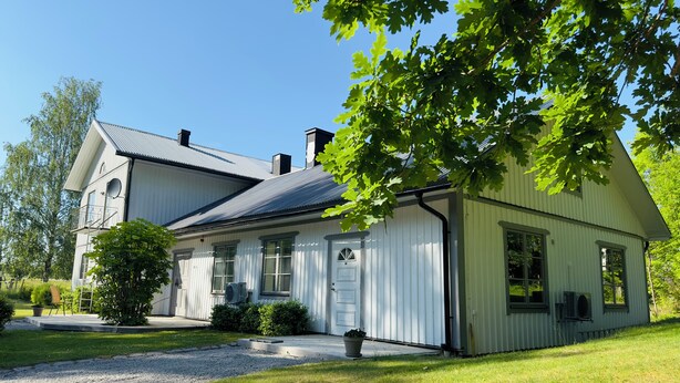 A two-story house with a white exterior, a grey roof, and a front porch. - Aspa Herrgård (Aspabruk)
