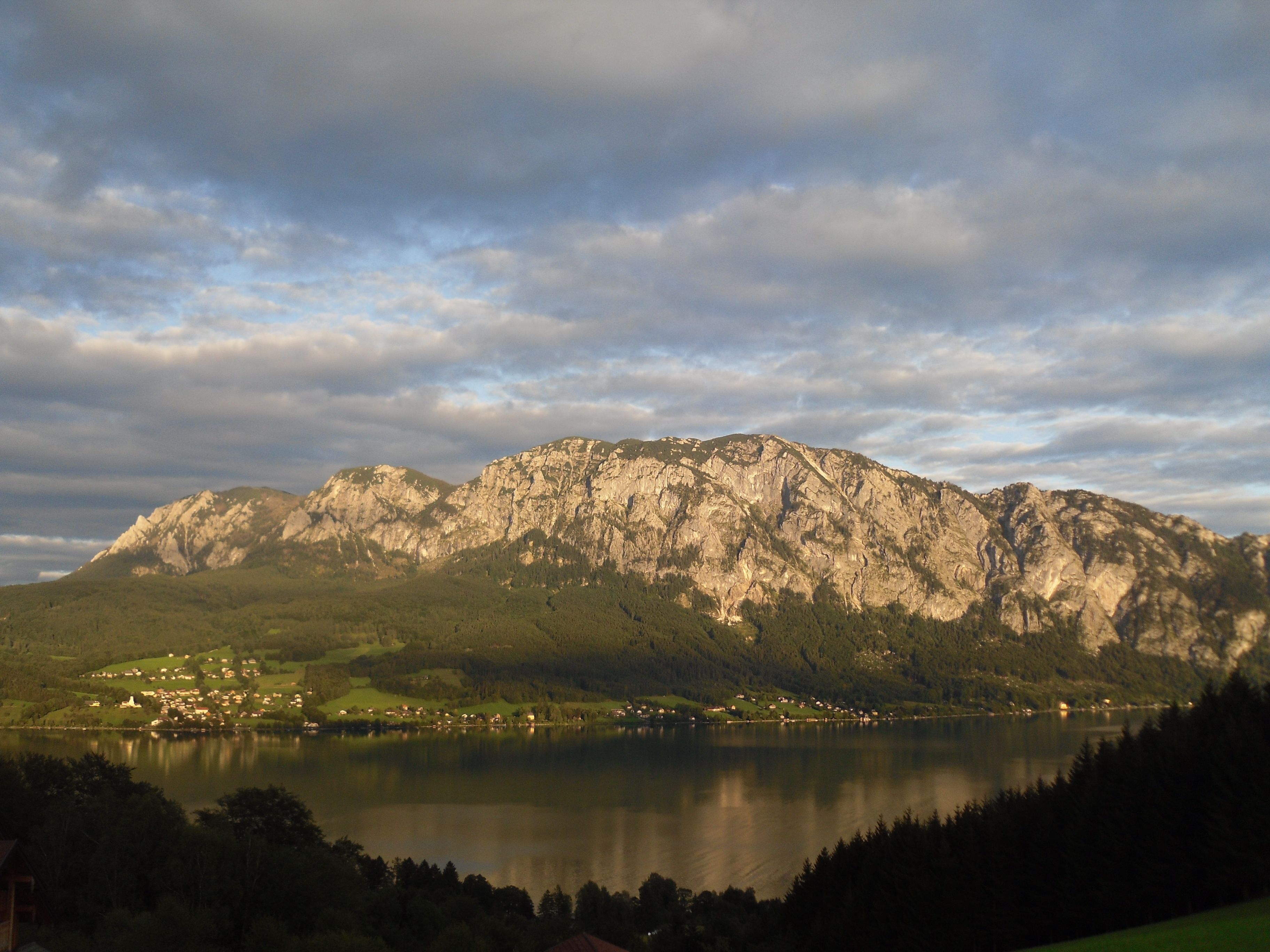 A mountainous landscape with a lake and scattered buildings.