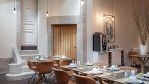 Un comedor con paredes de piedra, una puerta de madera y una cocina moderna con electrodomésticos.