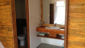 Ein Badezimmer mit einem Holzbadezimmermöbel, einem Waschbecken und einem Spiegel.