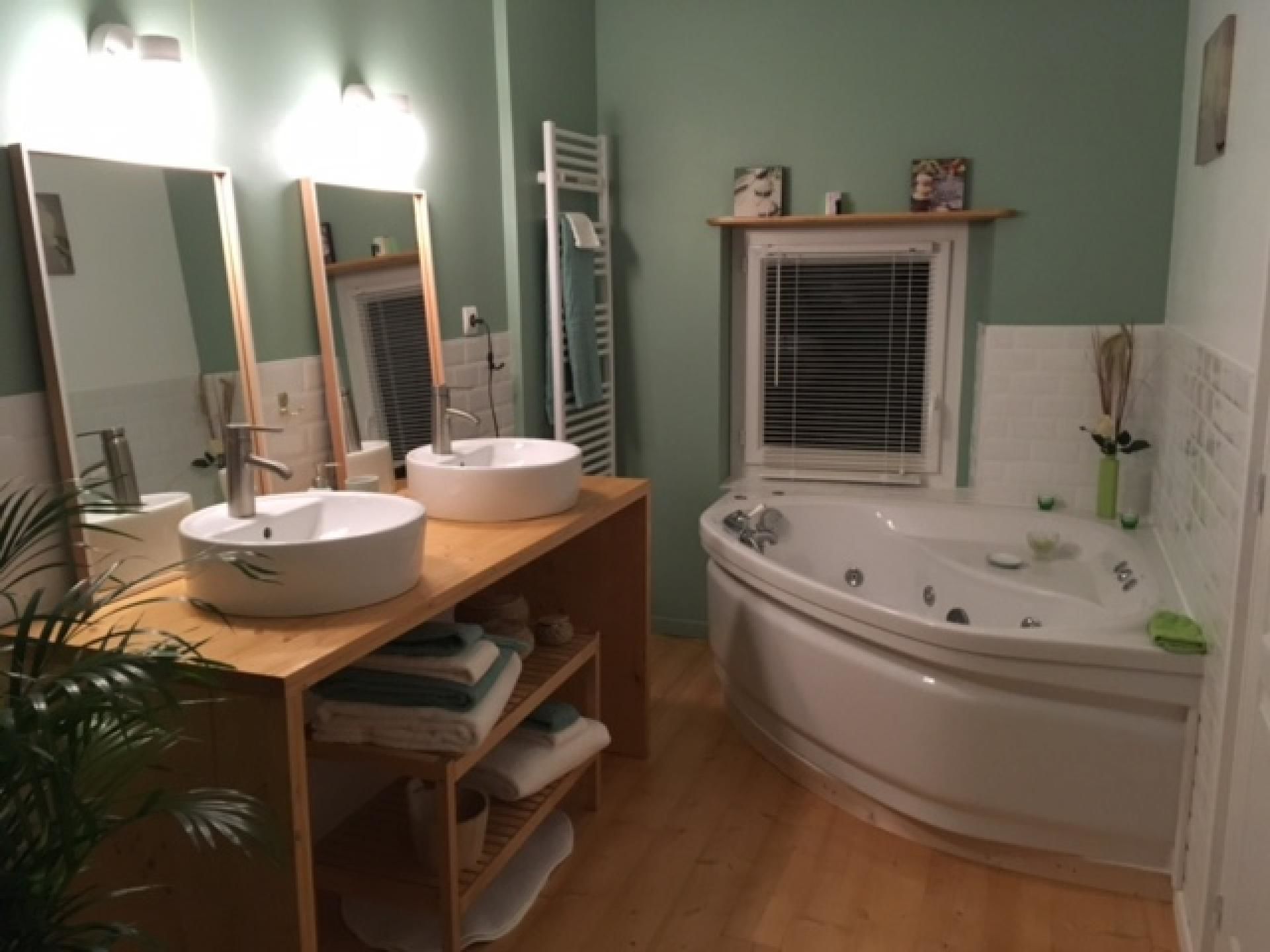 Un baño con dos lavamanos, una bañera y un espejo.