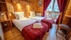 A wooden cabin with two beds, a red blanket, a wooden ladder, and a window with a view. - Hôtel du Centre (Valloire)