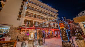 A multi-story building with a bar and restaurant on the ground floor, a sign for 'Le Centre', and a Christmas tree decoration. - Hôtel du Centre (Valloire)