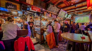 A busy bar with wooden interiors and a variety of items on display, including a Coca-Cola sign. - Hôtel du Centre (Valloire)