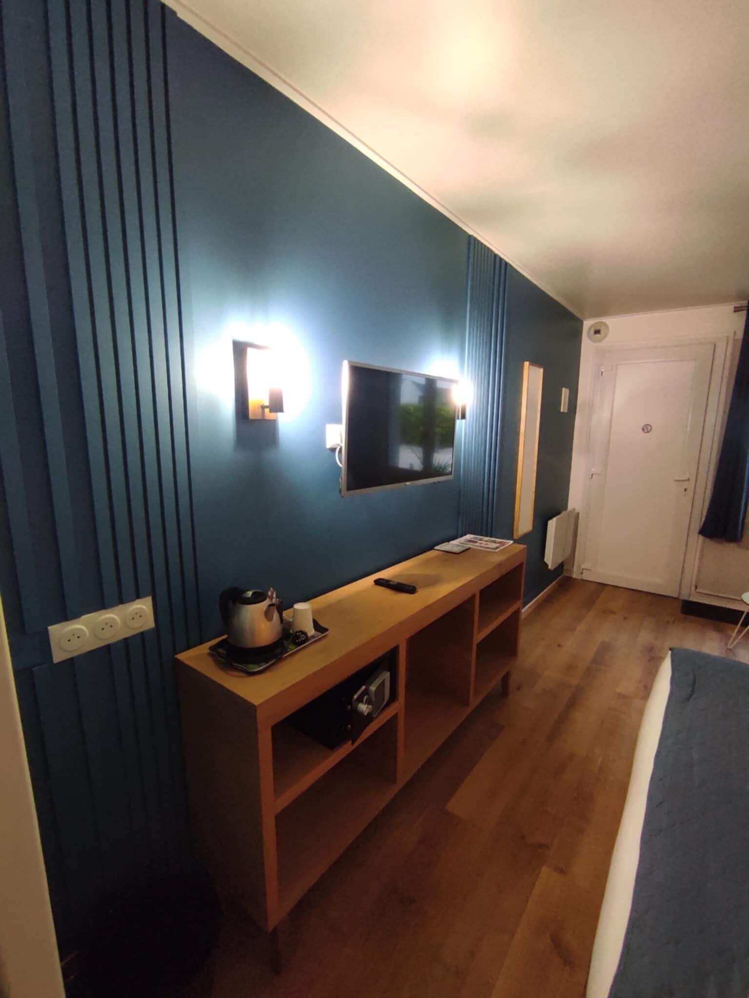 Een kamer met een houten console en een flatscreen televisie aan de muur, plus een deur met slot.