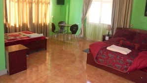 Una habitación con cama, escritorio, silla y televisor.