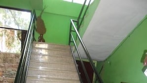 Una escalera con barandales de metal que sube a un piso superior.