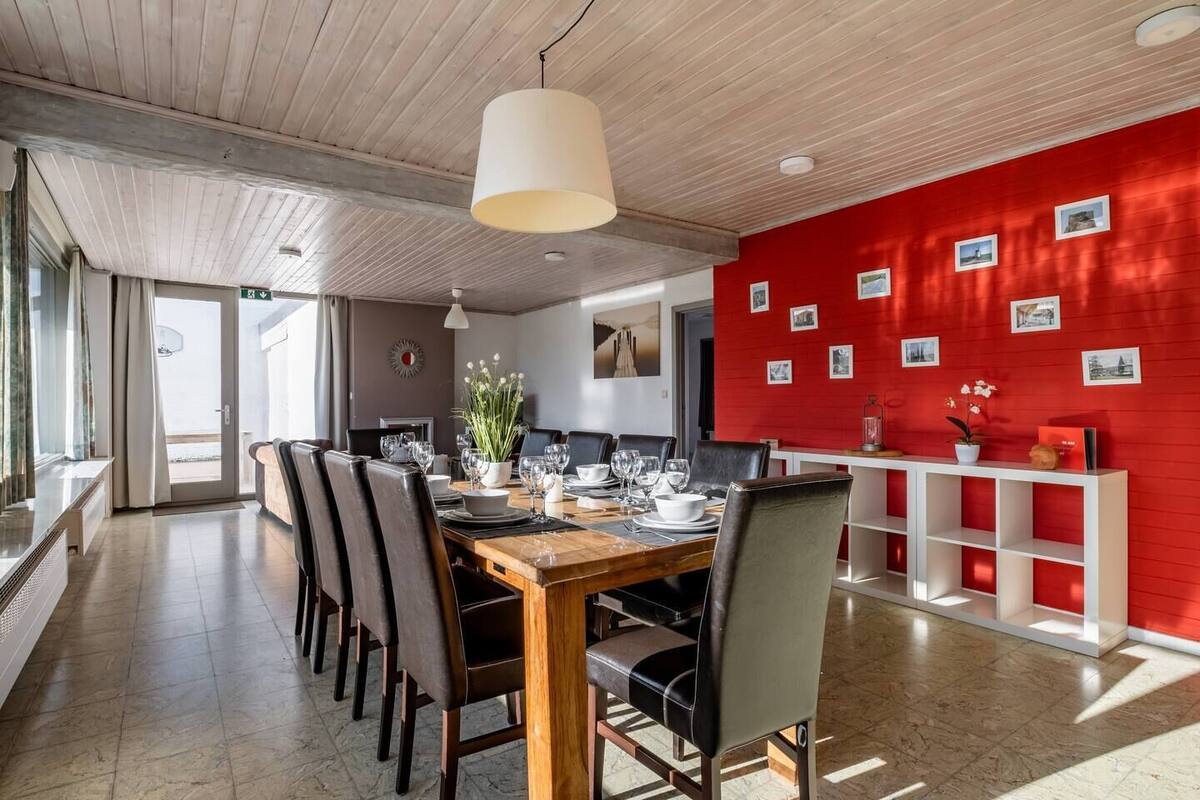 Comedor con mesa de madera dispuesta para seis personas, rodeada de sillas.