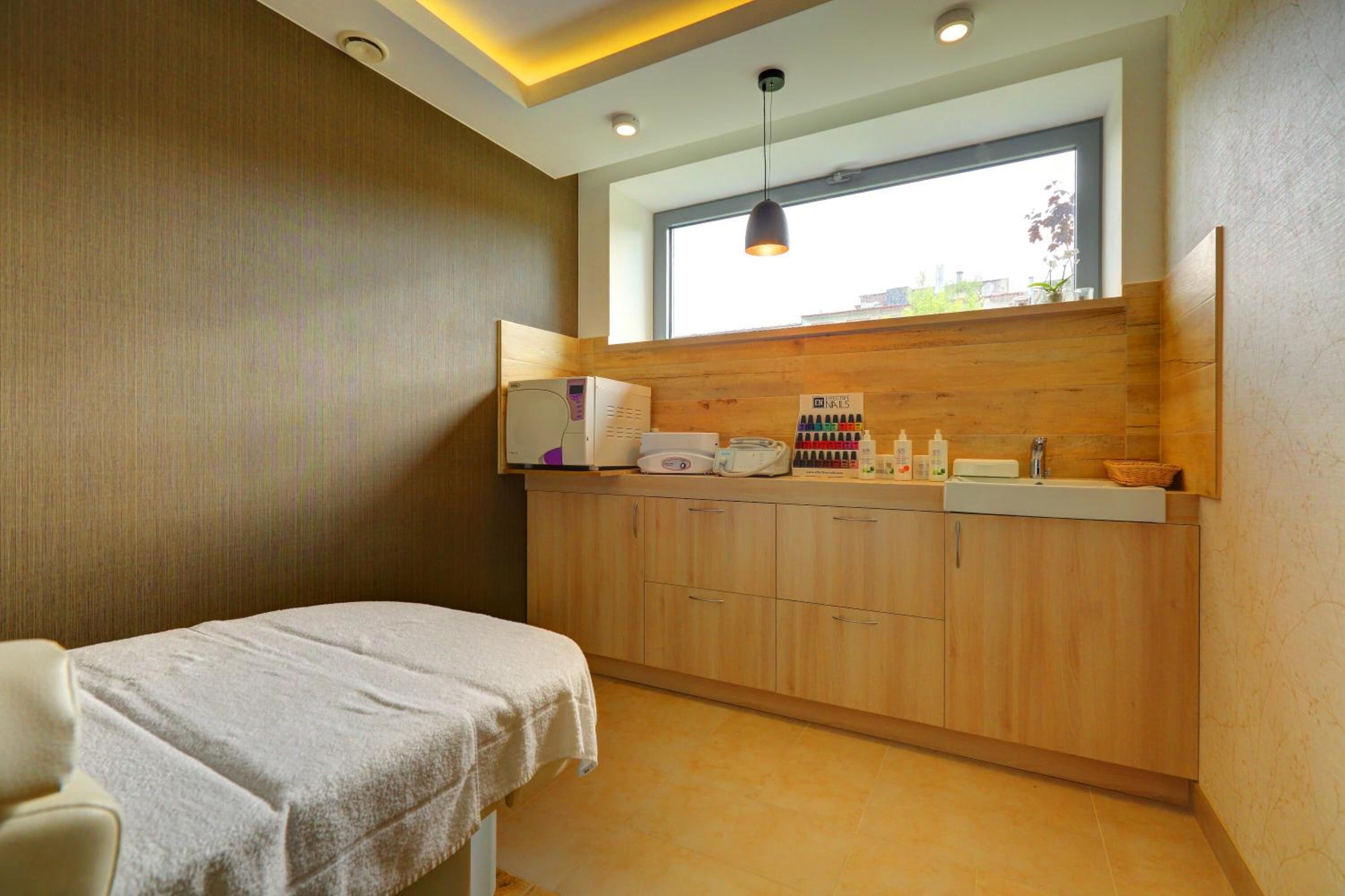 A modern bathroom with a wooden vanity, a towel, and a window providing natural light.