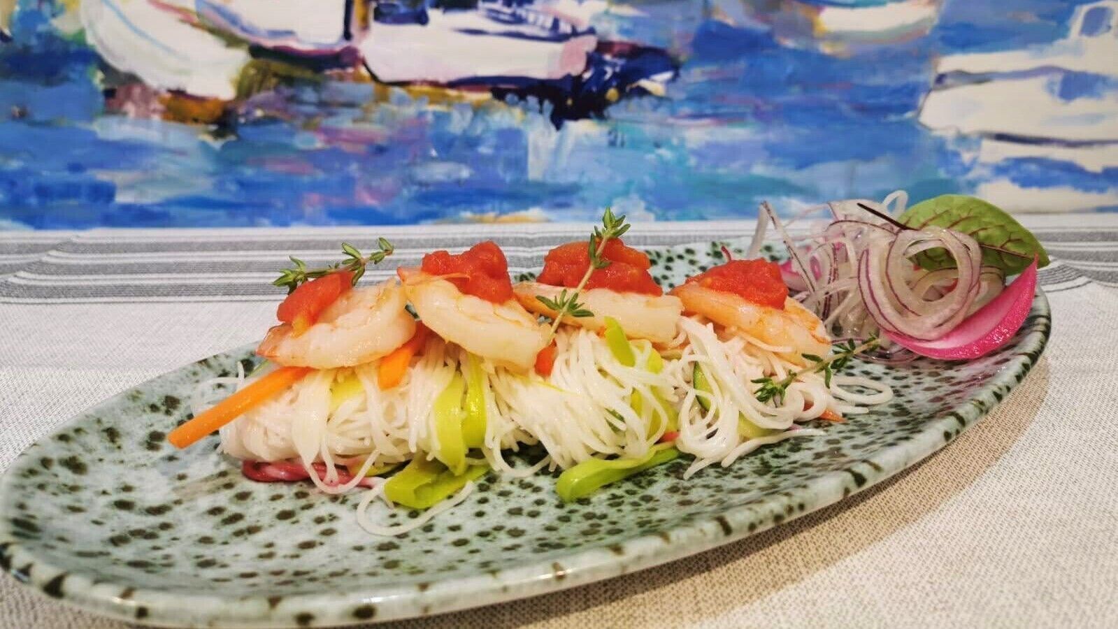 A plate of shrimp and vegetables on a speckled ceramic plate.