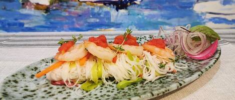 A plate of shrimp and vegetables on a speckled ceramic plate.