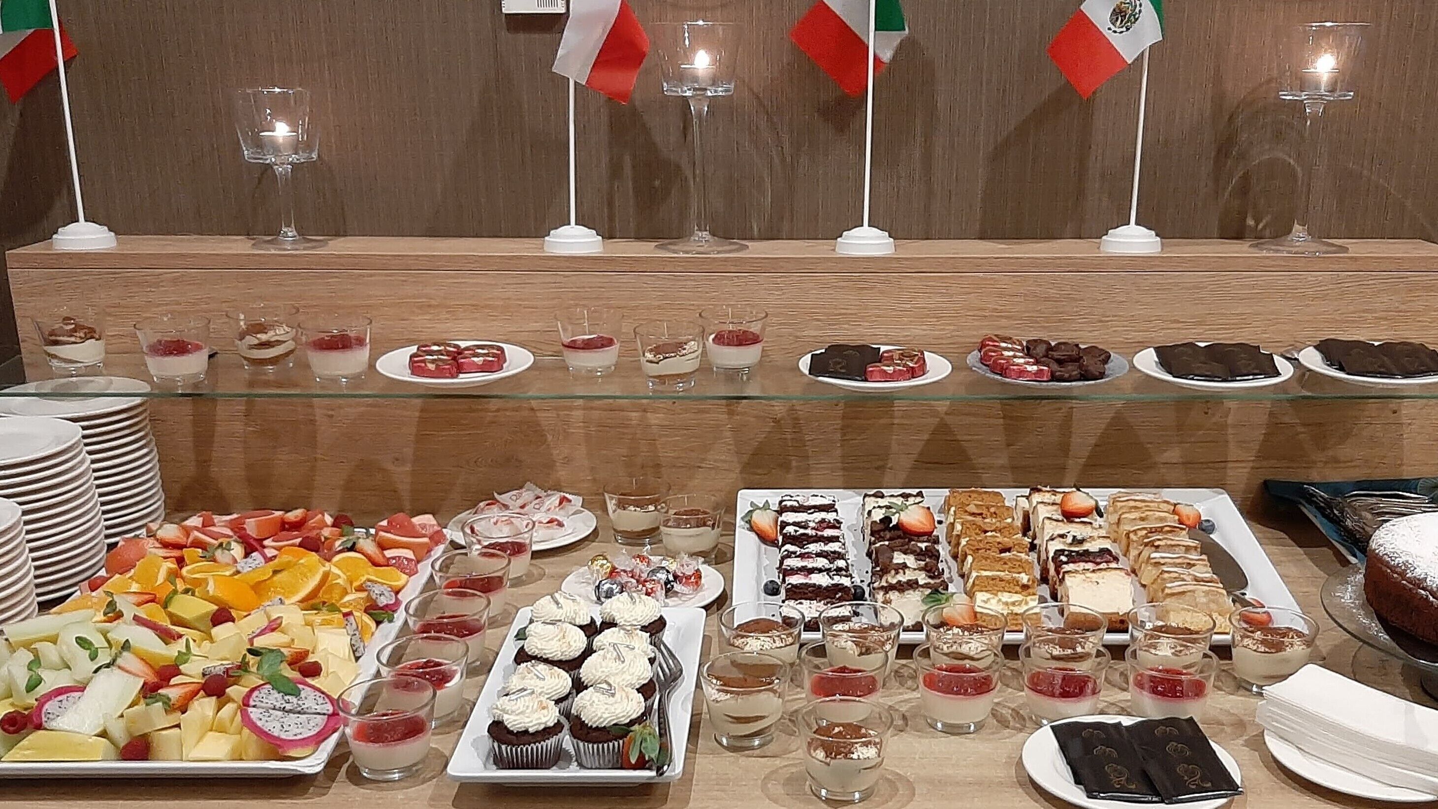 A buffet with various desserts and fruits, including cakes, pastries, and fruit platters.