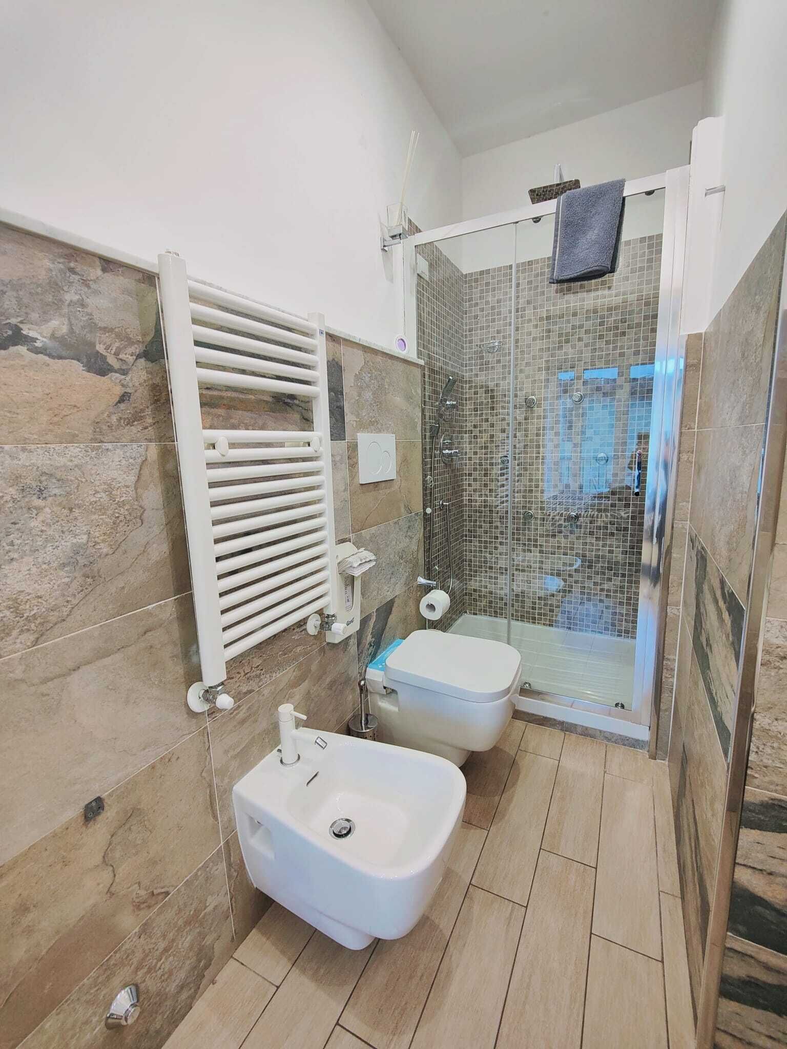 Une salle de bain équipée d’une douche, d’un bidet et de toilettes.