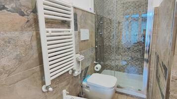 Une salle de bain équipée d’une douche, d’un bidet et de toilettes.