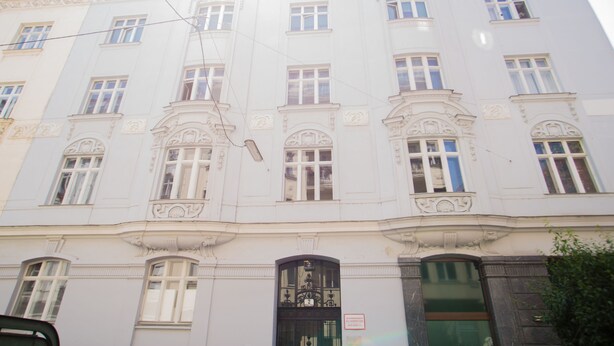 A multi-story building with ornate architectural details, including decorative moldings and a series of windows.