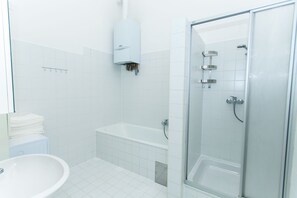 A modern bathroom with a glass-enclosed shower, a standalone bathtub, and a pedestal sink. - Vienna Hotspot - Staatsoper (Vienna)