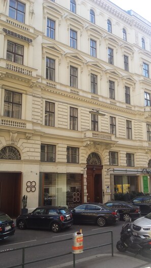 A multi-story building with a classic architectural style, featuring ornate window frames and decorative moldings. - Vienna Hotspot - Staatsoper (Vienna)