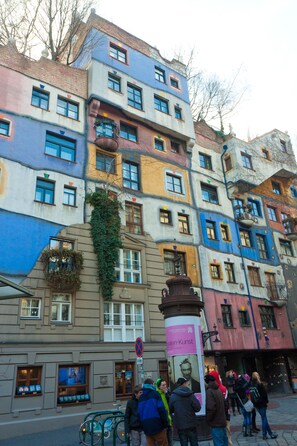 A colorful building with multiple balconies and a statue in front.