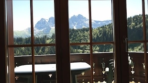 A room with a large window offering a view of a mountainous landscape.