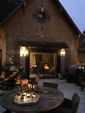 A rustic building with a circular window and a door leading inside.